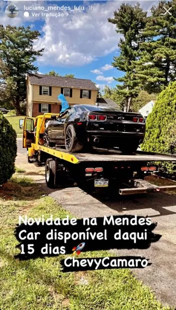 Chevrolet Camaro preto sendo descarregado da cegonha na frente da casa do cliente